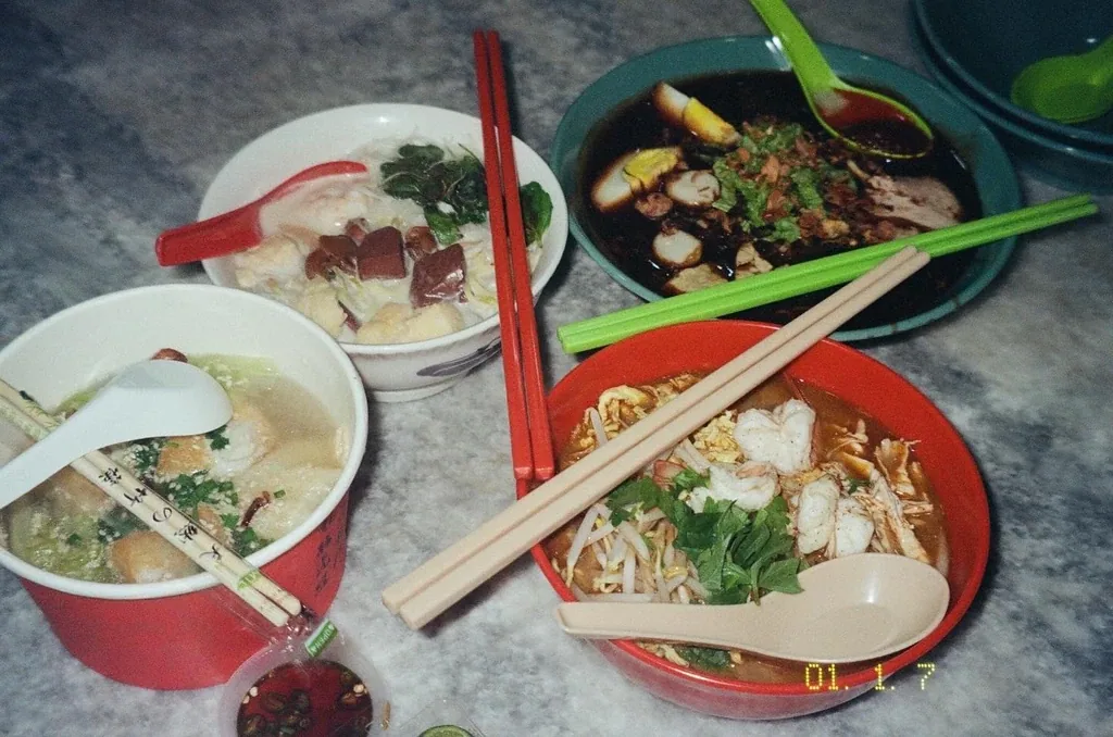 Bowls of Asian noodle soup and dumplings on a marble table